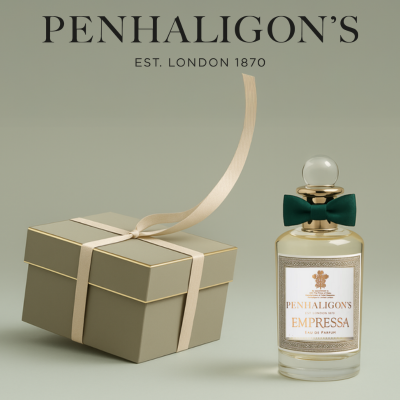 Penhaligon’s Parfumflakon „Empressa“ mit goldener Kappe und grüner Schleife, elegant inszeniert neben einer edlen, gold-grünen Geschenkbox mit Schleifenband. Darüber das Logo „Penhaligon’s – Est. London 1870“ auf zartgrünem Hintergrund.